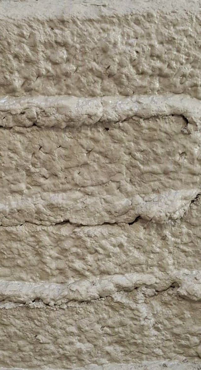 Close-up of a test print made with regolith-simulant material, showing the layered bead structure left by each pass of the nozzle.